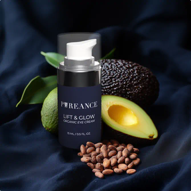 Pureance Lift & Glow eye cream with avocado and shea nuts on a dark fabric background