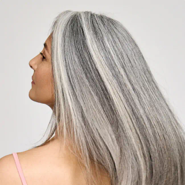 Woman with long, healthy gray hair showing smooth texture and shine