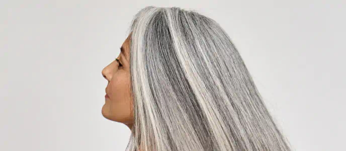Woman with long, healthy gray hair showing smooth texture and shine