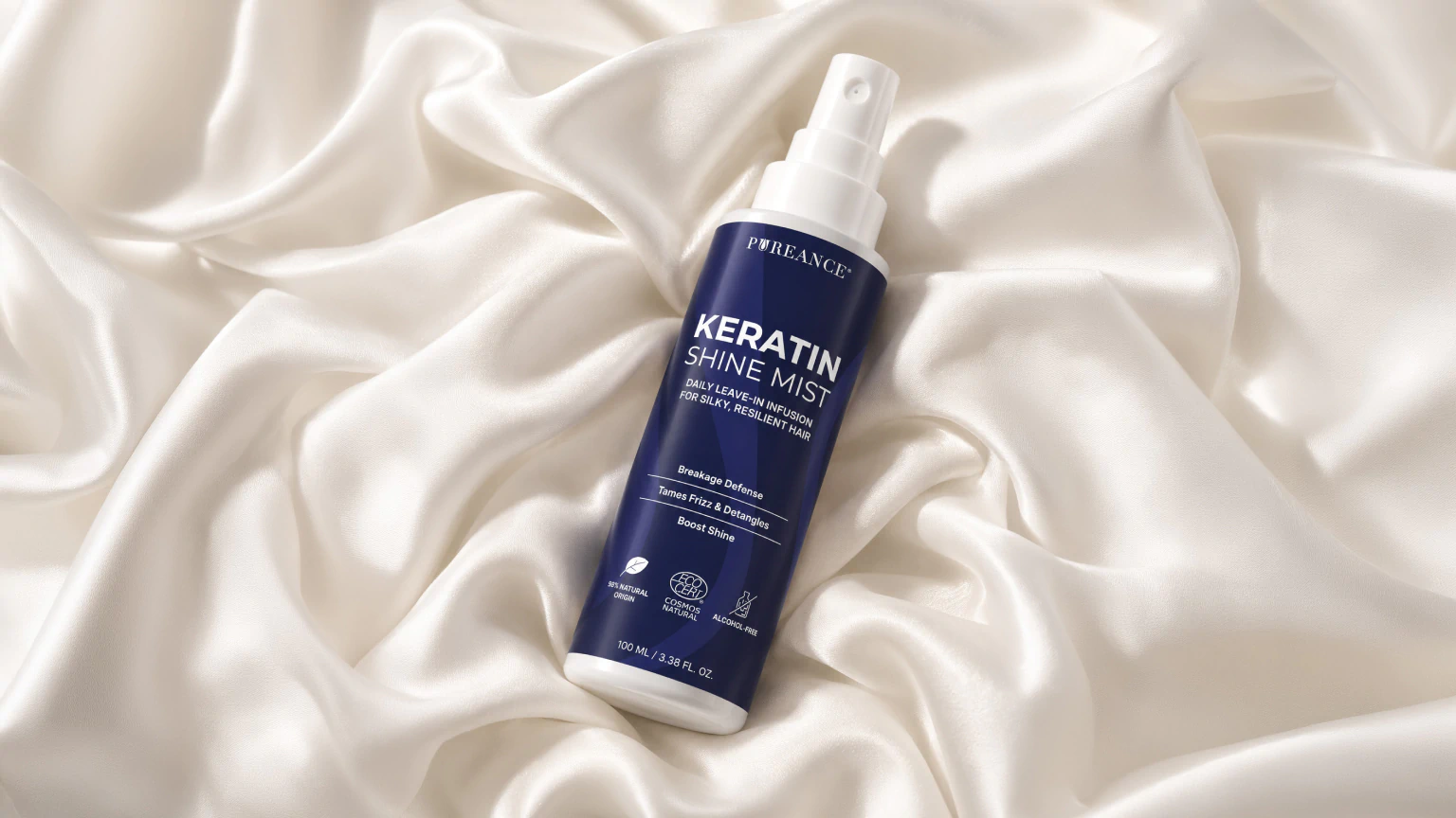 Pureance Keratin Shine Mist bottle resting on white silk
