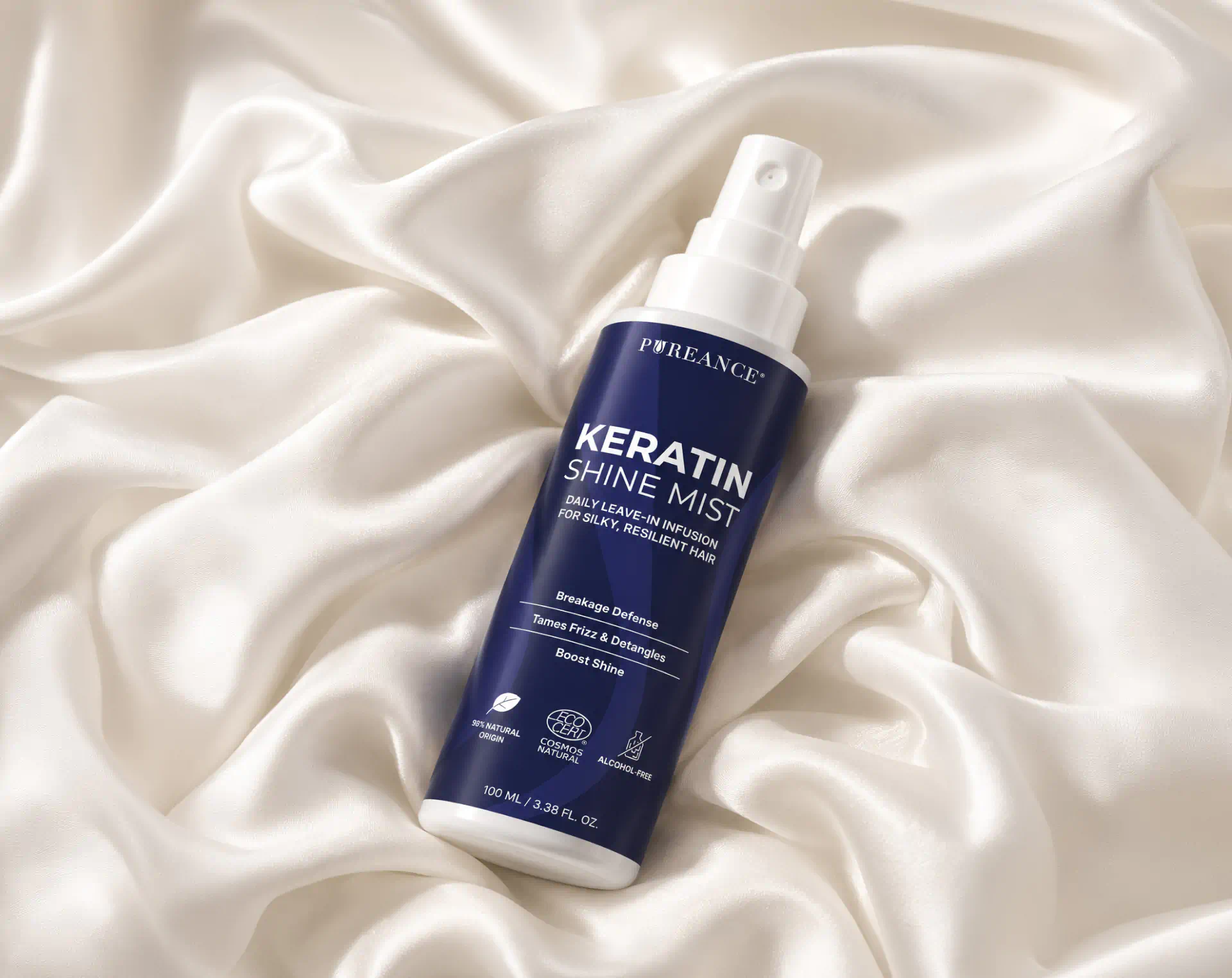 Pureance Keratin Shine Mist bottle resting on white silk